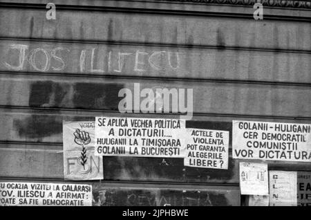 Bukarest, Rumänien, April 1990. „Golaniada“, ein großer Anti-Kommunismus-Protest auf dem Universitätsplatz nach der rumänischen Revolution von 1989. Die Menschen versammelten sich täglich, um gegen die Ex-Kommunisten zu protestieren, die nach der Revolution die Macht ergriffen hatten. Am Universitätsgebäude hingen verschiedene Plakate. Stockfoto