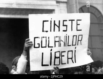 Bukarest, Rumänien, April 1990. „Golaniada“, ein großer Anti-Kommunismus-Protest auf dem Universitätsplatz nach der rumänischen Revolution von 1989. Die Menschen versammelten sich täglich, um gegen die Ex-Kommunisten zu protestieren, die nach der Revolution die Macht ergriffen hatten. Als Präsident Iliescu sie "golani" (Hooligans) nannte, nahmen die Demonstranten den Begriff stolz an und trugen ihn als Abzeichen. Dieses Banner sagt 'Respekt vor den freien Hooligans' Stockfoto