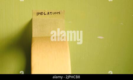 Inflation Wort auf Klebeband isoliert grüne schmutzige Wand geschrieben Stockfoto