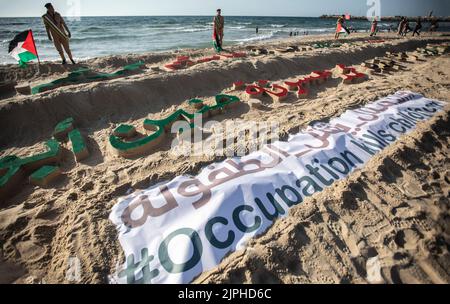 Gaza, Palästina. 17. August 2022. Die Namen der 17 Kinder, die bei der jüngsten Bombardierung des Gazastreifens durch Israel getötet wurden, sind während der Demonstration am Ufer von Gaza-Stadt eingraviert. Ende des 7. August 2022 wurde ein von Ägypten vermittelter Waffenstillstand erreicht, der den 3-tägigen Konflikt zwischen Israel und Gaza beendete. (Foto von Yousef Masoud/SOPA Images/Sipa USA) Quelle: SIPA USA/Alamy Live News Stockfoto