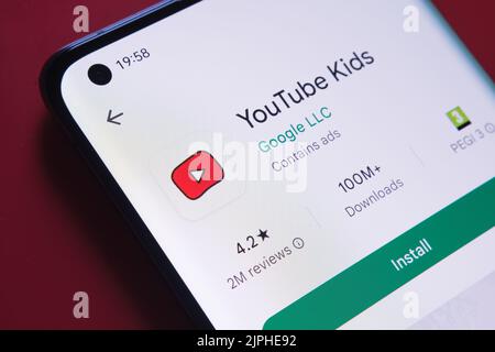 YouTube Kids App im Google Play Store auf dem Smartphone-Bildschirm auf rotem Hintergrund gesehen. Nahaufnahme mit selektivem Fokus. Stafford, Vereinigte Ki Stockfoto