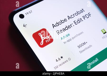 adobe acrobat PDF-App im Google Play Store auf dem Smartphone-Bildschirm auf rotem Hintergrund angezeigt. Nahaufnahme mit selektivem Fokus. Stafford, Einheit Stockfoto