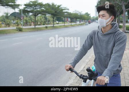 Radfahrer in Gesichtsmaske wegen Smog in der Stadt Stockfoto