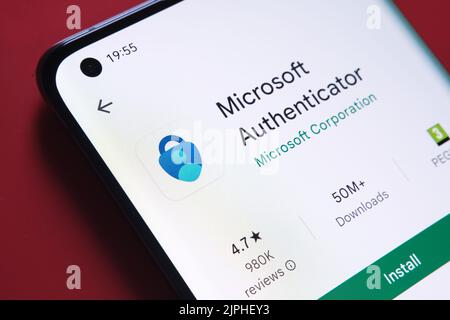 Microsoft Authenticator-App im Google Play Store auf dem Smartphone-Bildschirm auf rotem Hintergrund angezeigt. Nahaufnahme mit selektivem Fokus. Stafford Stockfoto