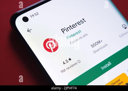 Pinterest-App im Google Play Store auf dem Smartphone-Bildschirm auf rotem Hintergrund angezeigt. Nahaufnahme mit selektivem Fokus. Stafford, Großbritannien Stockfoto