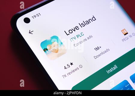 Love Island App im Google Play Store auf dem Smartphone-Bildschirm auf rotem Hintergrund zu sehen. Nahaufnahme mit selektivem Fokus. Stafford, United Kin Stockfoto
