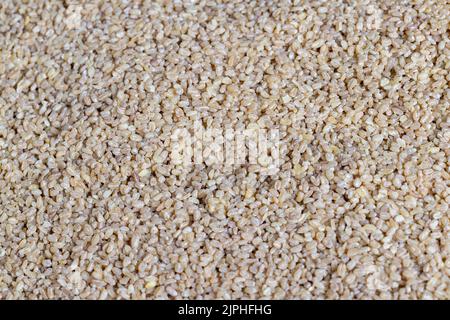 Auf dem Tisch liegt frischer, ungekochte Bulgur-Haferbrei, der Gerichte aus traditionellen östlichen Bulgur-Cerealien zubereitet Stockfoto