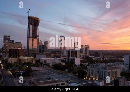 Die Skyline von Austin, Texas, die südwestlich vom Texas Capitol an einem warmen Sommerabend im August liegt. Das große Gebäude auf der linken Seite ist das Büro- und Wohngebäude von 6. und Guadalupe im Bau. Stockfoto