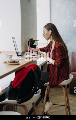 Produktiveres Arbeiten. Junge Studentin, Freiberuflerin, die mit einem Laptop arbeitet Stockfoto