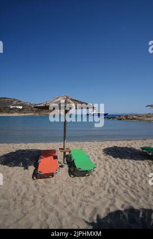 Leere Sonnenliegen und Sonnenschirme am herrlichen Strand von Manganari in iOS Griechenland Stockfoto