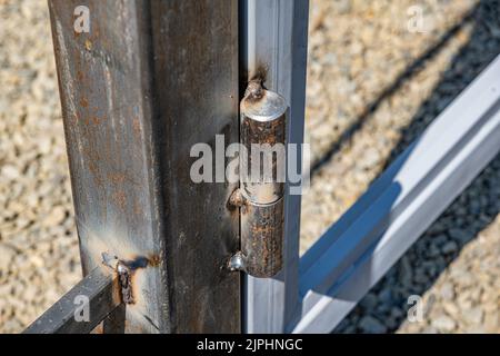 Metallscharnier am Tor. Stockfoto