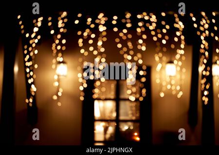 Weihnachtslichter und Girlanden schmücken den Weg vor dem Eingang zum Restaurant. Das Konzept, das neue Jahr im Restaurant zu feiern. Hochwertige Fotos Stockfoto