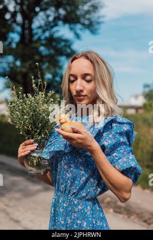 Schönes Mädchen mit Wildblumen und Entchen in ihren Händen Stockfoto