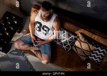 Zu Hause, online, mit gekreuzten Beinen, Smartphone, zu Hause, Online, Cross-Leggeds, Smartphones, Smartphones, Smartphones Stockfoto