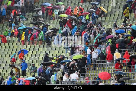 München, Deutschland. 18. August 2022. Europameisterschaften, Leichtathletik, im Olympiastadion. Zuschauer mit Schirmen verlassen die Sitze. Aufgrund einer Sturmwarnung wurden die Wettkämpfe unterbrochen. Quelle: Sven Hoppe/dpa/Alamy Live News Stockfoto