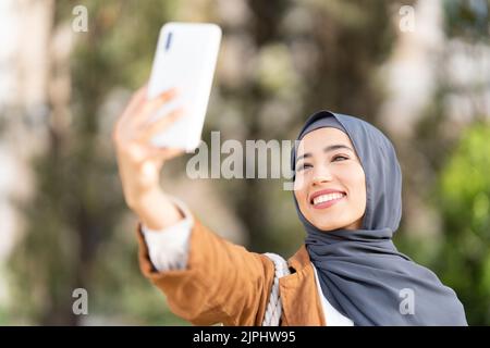 Muslimische Frau, die in einem Park ein Selfie gemacht hat Stockfoto