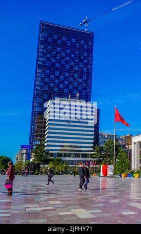 Vertikale Straßenaufnahme von Menschen, die auf dem Skanderbeg-Platz im Zentrum von Tirana, Albanien, spazieren gehen Stockfoto