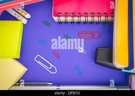 Flatlay von Büro- und Schulsachen auf farbigem Hintergrund. Stockfoto