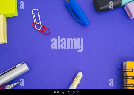 Flatlay von Büro- und Schulsachen auf farbigem Hintergrund. Stockfoto