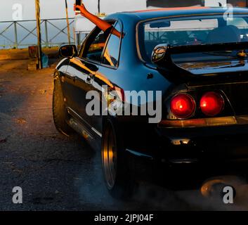 Eine wunderschöne Aufnahme einer schwarzen R32, die mit einem Burnout in Trinidad und Tobago aufgeht Stockfoto