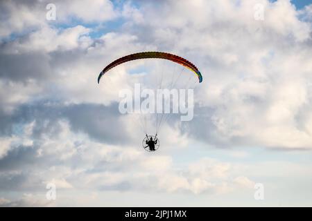 Ein Pilot, der einen Luna 2-Paramotor fliegt und sich nach einem frühen Sommerflug auf den Gipfel der Großen Orme in Llandudno vorbereitet Stockfoto