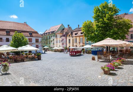 Stadtplatz mit alten hellen Häusern im mittelalterlichen Zentrum von Sighișoara in Siebenbürgen, Rumänien. Stockfoto