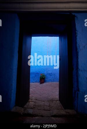 Eine offene Tür eines alten Gebäudes mit blauen Wänden Stockfoto