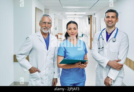 Eine Gruppe von medizinischem Personal in Uniform, die am Krankenhausflur zusammenstehen. Team von Ärzten und Krankenschwester für medizinische Unterstützung und Pflege Stockfoto