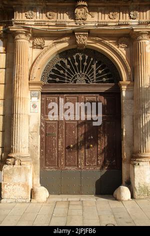 Schöner Eingang zu einem alten Gebäude im historischen Zentrum von Carovigno, Italien. Stockfoto