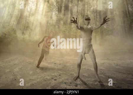 Mama und Zombie gehen mit Klauenhänden in den verwunschenen Wald. Halloween-Konzept Stockfoto