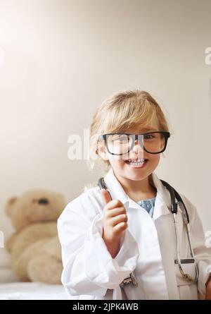 Deckt Ihre medizinische Hilfe Ihren Nachwuchs ab. Portrait eines entzückenden kleinen Mädchens, das als Arzt verkleidet ist. Stockfoto