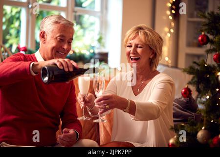 Glücklich, weihnachten, Gießen, Champagner, älteres Paar, Frohe weihnachten, Weihnachten, Weihnachten, Champagner, Champagner, ältere Paare Stockfoto