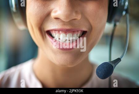 Wie kann ich helfen? Eine junge Frau, die in einem Callcenter arbeitet. Stockfoto