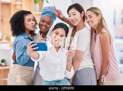 Lustige, abwechslungsreiche und verspielte Team-Selfie am Telefon und Spaß haben, herumtollen oder Friedenszeichen-Geste machen. Fröhliche goofy Gruppe von Geschäftsfreunden oder Stockfoto