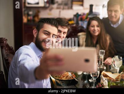 Erstes Familien-Selfie für den Tag. Eine Familie, die während des Abendessens zu Hause ein Selfie gemacht hat. Stockfoto
