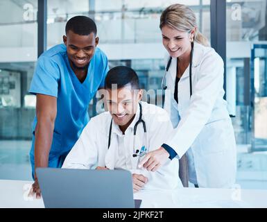 Ärzte, medizinische Fachkräfte oder Mitarbeiter im Gesundheitswesen mit Laptop sprechen, treffen oder planen medizinische Behandlung. Vielfältige Gruppe von glücklichen Klinik Stockfoto