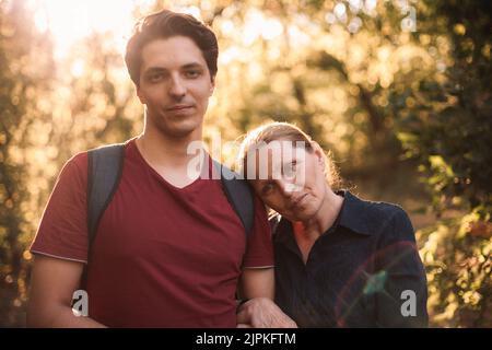 Porträt einer nachdenklichen Mutter und eines Sohnes, die im Sommer im Park stehen Stockfoto