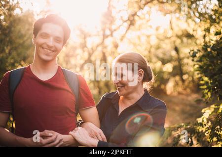 Portrait von glücklicher Mutter und Sohn, die im Sommer im Park stehen Stockfoto
