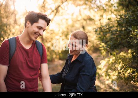 Glückliche Mutter und Sohn lachen, während sie im Sommer im Park stehen Stockfoto