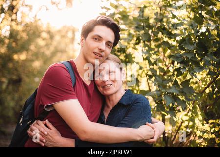 Portrait von glücklicher Mutter und Sohn, die sich im Sommer im Freien umarmen Stockfoto