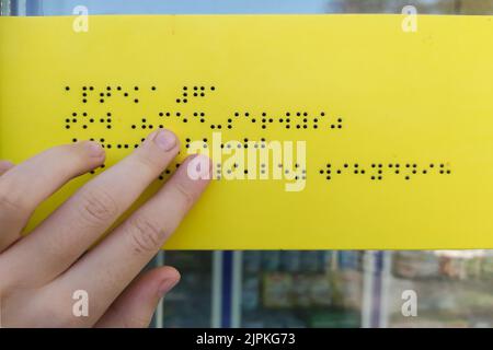 Die Hand des Mädchens liest im Freien Brailleschrift Stockfoto