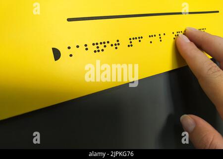 Frau liest Braille-Text von Hand Stockfoto