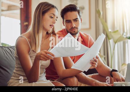 Budget, Schulden und Hypotheken mit einem Paar Rechnungen und Dokumente lesen, während ihre Ausgaben und Einsparungen zu überprüfen. Ehemann und Ehefrau sehen besorgt aus Stockfoto