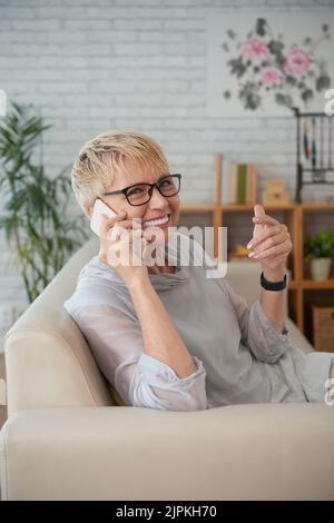 Glückliche, alte junge Frau, die am Telefon anruft Stockfoto