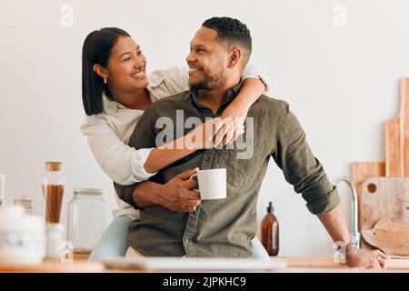 Glücklich, Kaffee und liebende Paar verbindet und Spaß haben, während die Zeit zusammen zu Hause verbringen. Lächelnd, verliebt und unbeschwert Paar umarmen und teilen Stockfoto