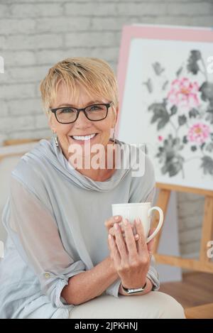 Porträt einer glücklichen, kreativen Senior-Frau mit einer Tasse Kaffee Stockfoto