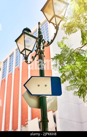 Sie werden hier nie die Richtung verlieren. Ein Wegweiser auf einer Straßenlaterne draußen während des Tages. Stockfoto