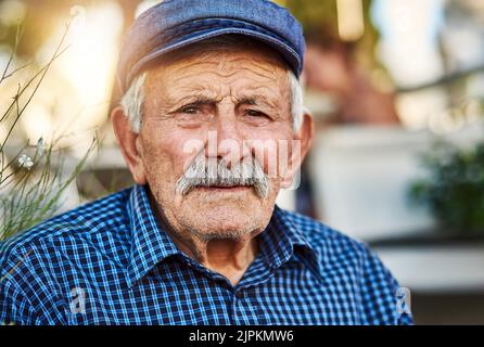 Er lebt für immer in dieser Stadt. Porträt eines selbstbewussten älteren Mannes, der draußen steht, während er die Kamera anschaut. Stockfoto