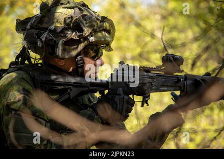 11. August 2022 - Ahvenanmaan Maakunta (Fi), Finnland - Ein Soldat der Finnischen Marine High Readiness Unit patrouilliert während des bilateralen Trainings auf der Insel Russaro, Finnland, im August mit US-Marineinfanatikerinnen, die der Marine Expeditionary Unit (MEU) 22. zugewiesen wurden. 11, 2022. Während des Trainings wurden US-Marineinfanteristen und finnische Soldaten integriert, um die Interoperabilität zwischen ihren Truppen zu erhöhen. Die Kearsarge Amphibious Ready Group, die 22. MEU unter dem Kommando und der Kontrolle der Task Force 61/2 einschiffte, befindet sich im geplanten Einsatzgebiet der US Naval Forces Europe, beschäftigt von der US Sixth Fleet To Stockfoto