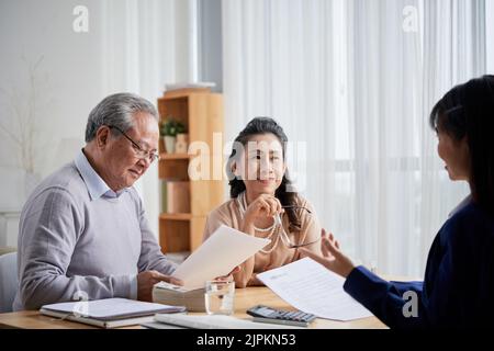 Asiatisch gealtertes Paar, das sich mit einem Immobilienmakler trifft Stockfoto